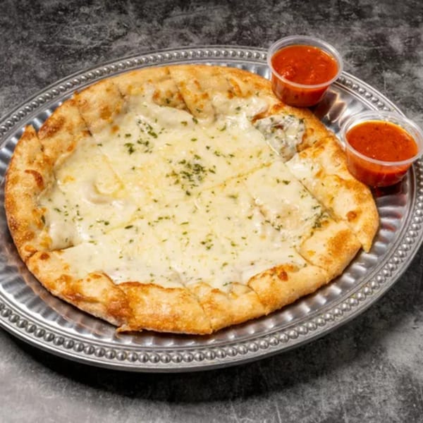 Cheesy garlic bread with herbs on a silver platter, served with two small cups of marinara sauce.